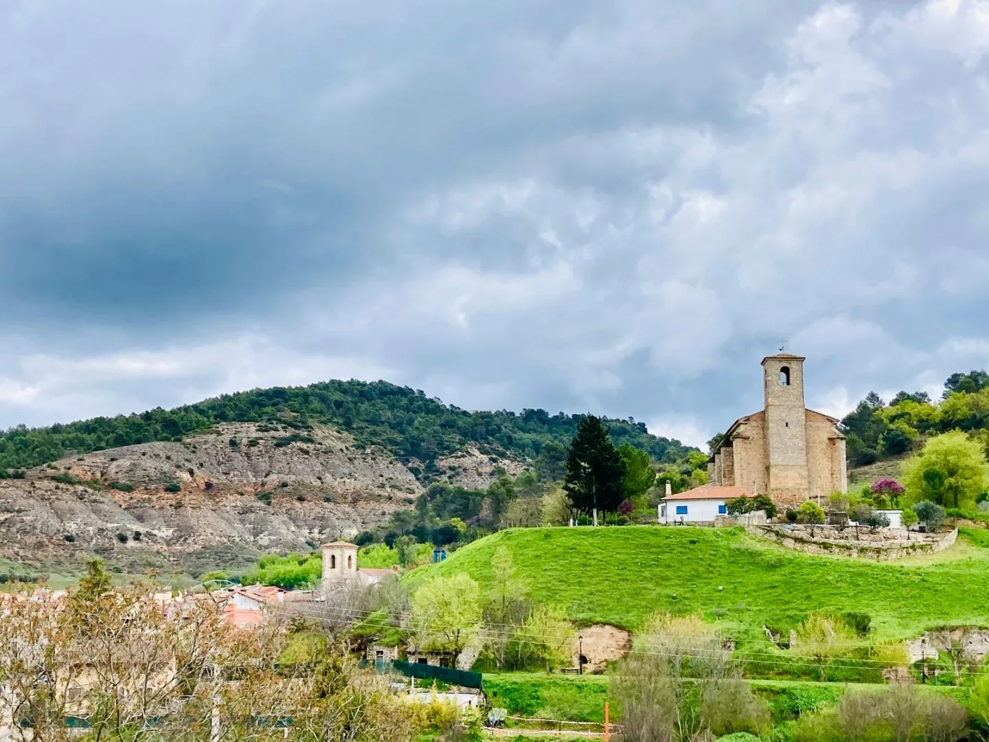 Iglesia y paisaje de Valdeconcha bajo cielo nublado